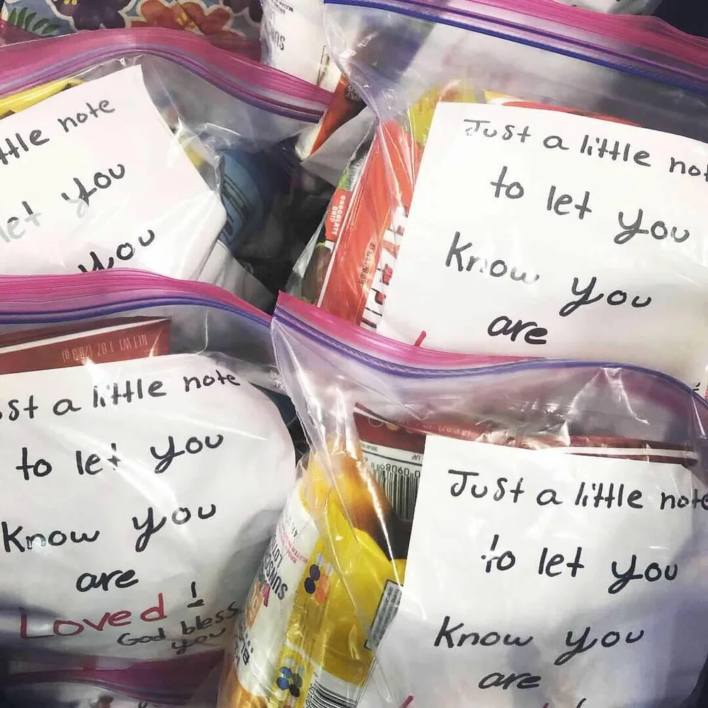 Care packages with handwritten notes reading 'Just a little note to let you know you are loved'