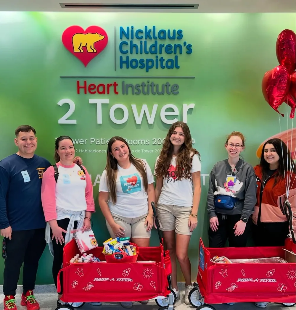 Volunteers with wagons of donated gifts at Nicklaus Children's Hospital Heart Institute